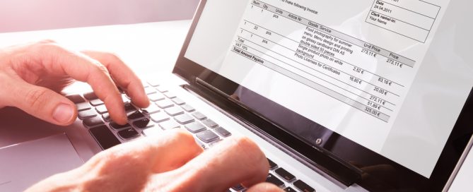 Close-up Of Businessman's Hands Working On Invoice