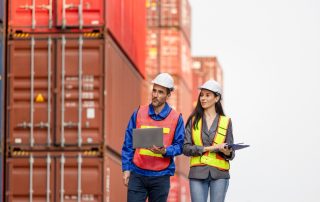 Engineers Inspecting Shipping Containers At Port Terminal