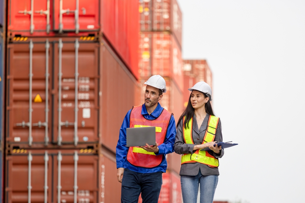 Engineers Inspecting Shipping Containers At Port Terminal