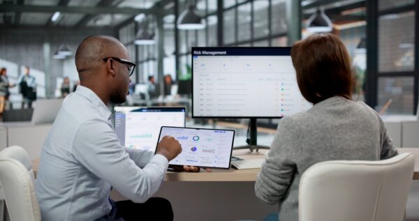 Professionals Using Multiple Screens To Monitor Data