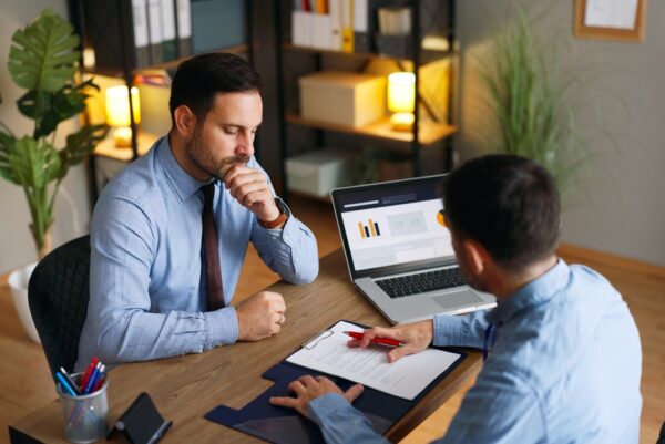 Businessmen Analyzing A Contract During A Financial Negotiation