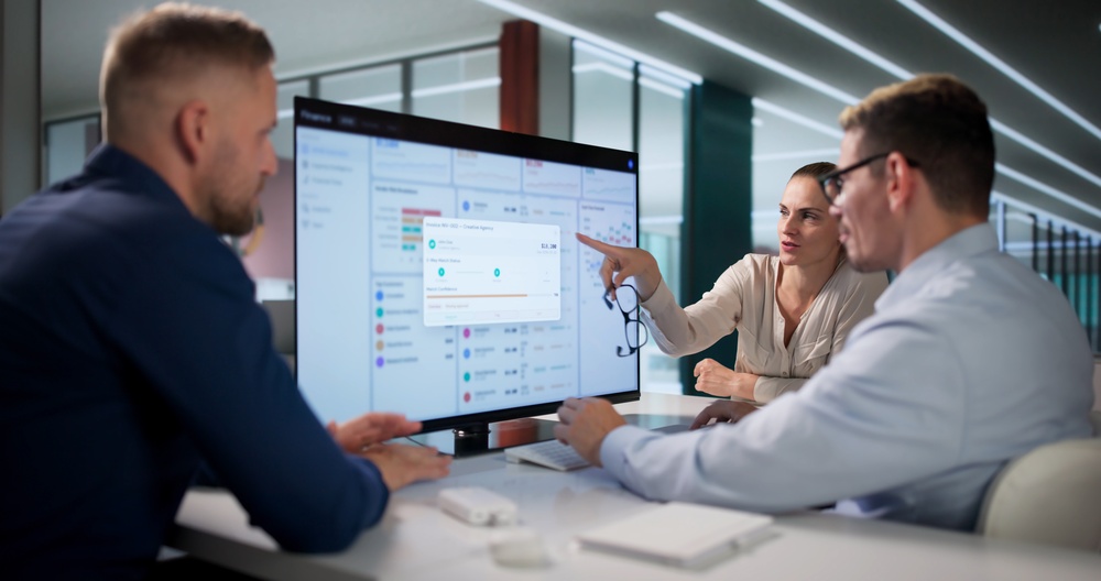 Team Of Financial Analysts Reviews Cloud-based Invoice Data Together