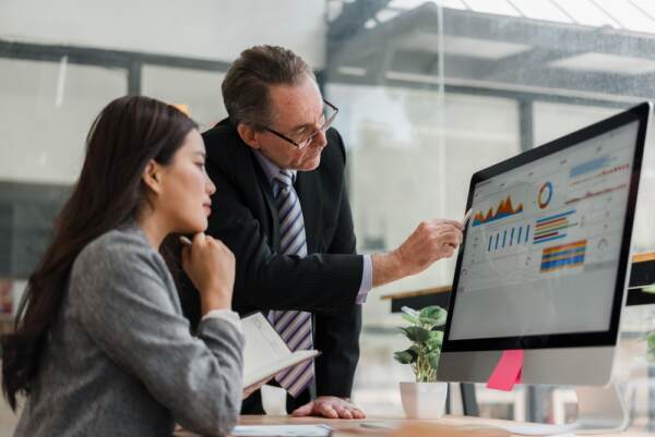 Business Mentor Analyzing Financial Data And Charts On A Computer