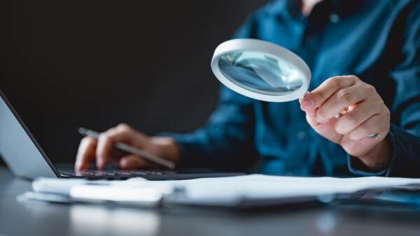 Business Professional Using A Magnifying Glass